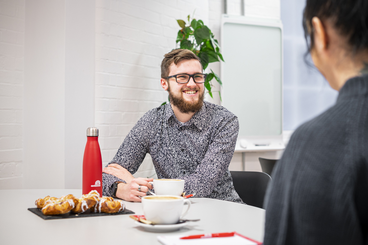 People in an Antenna meeting room drinking coffee