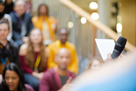 Male speaker with microphone talking to audience